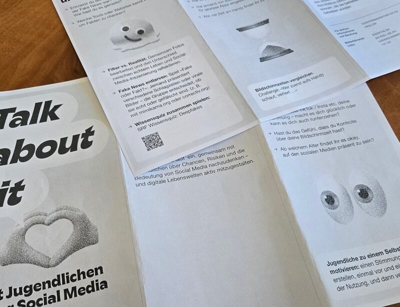 Ein aufgefächerter Papier-Flyer mit dem Titel «Talk about it – Mit Jugendlichen über Social Media sprechen», der die unlogische Aufteilung auf zwei separate Blätter zeigt.